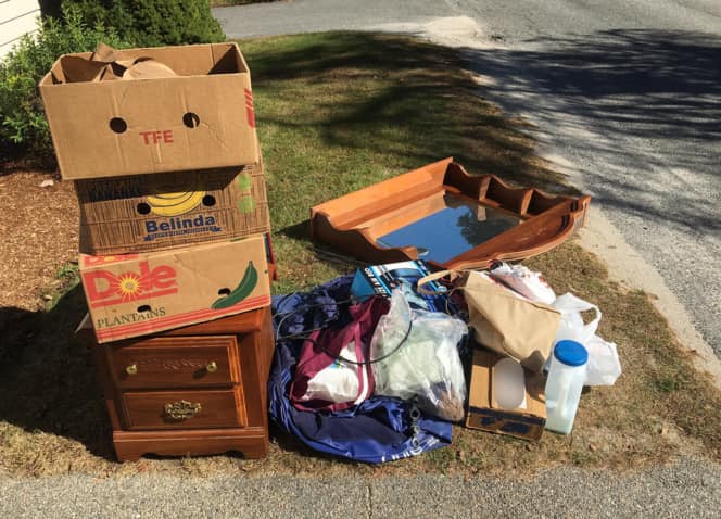 Picture of old furniture, boxes and household junk on a curbside awaiting contactless junk pickup service in riverside, ca